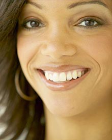 photo of a smiling woman wearing hidden lingual braces